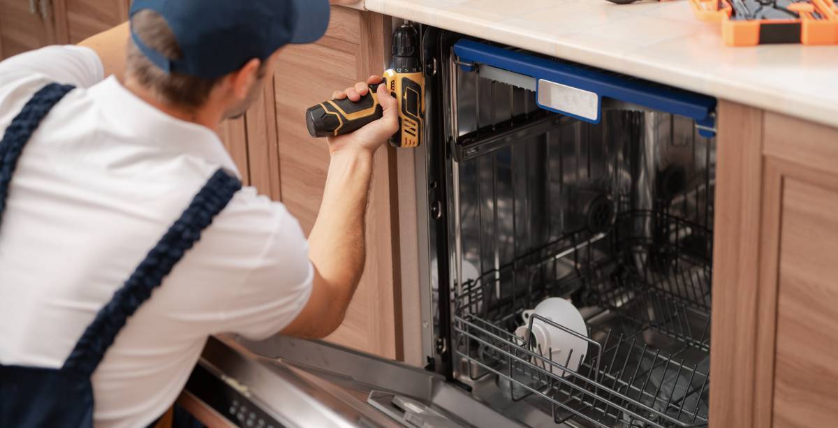 A,Man,Or,A,Service,Worker,In,Special,Clothes,Using A man or a service worker in special clothes using a screwdriver attaches to the countertop or removes the dishwasher.